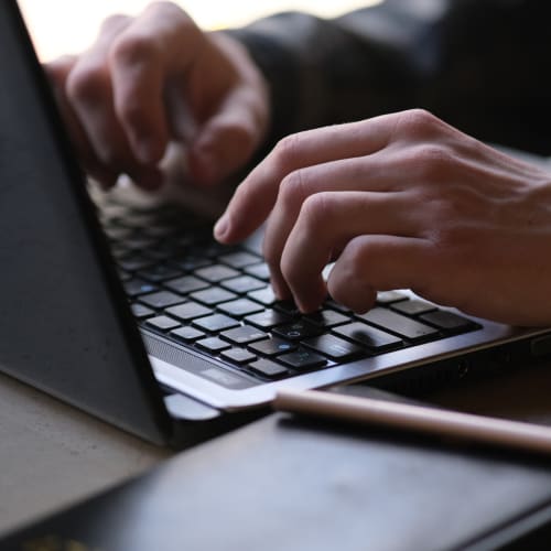 a person sat at a laptop typing