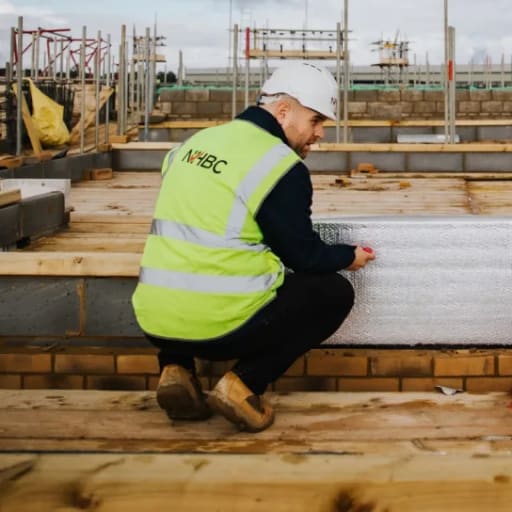 Two men on new build development site wearing safety jackets and hard hats