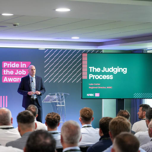 A man standing on stage speaking to a crowd of people