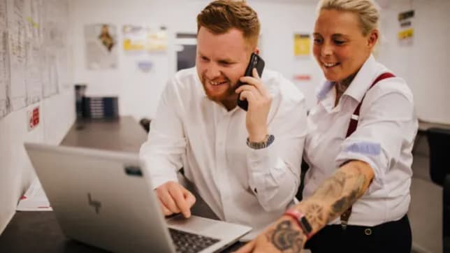 Man and woman looking at laptop in office room