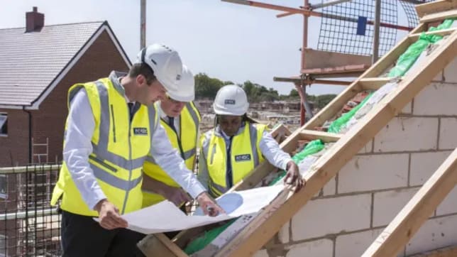 NHBC team in safety jackets and hard hats on a roof in development