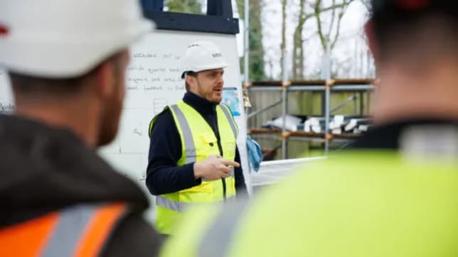 a person in a hard hat and hi-vis teaching at cambridge hub