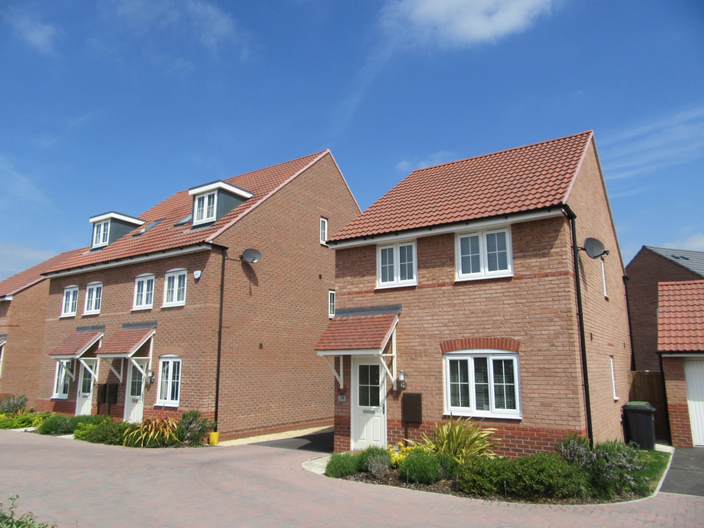 a photo of a row of red brick houses on a sunny day