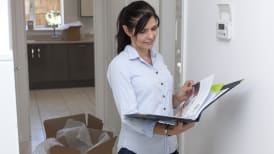 a woman reading her new home documents in her hallway