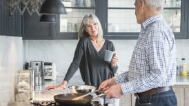 an older couple cooking and spending time together in the kitchen