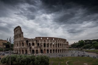 A photo of the Colosseum of Rome with very threatening clouds