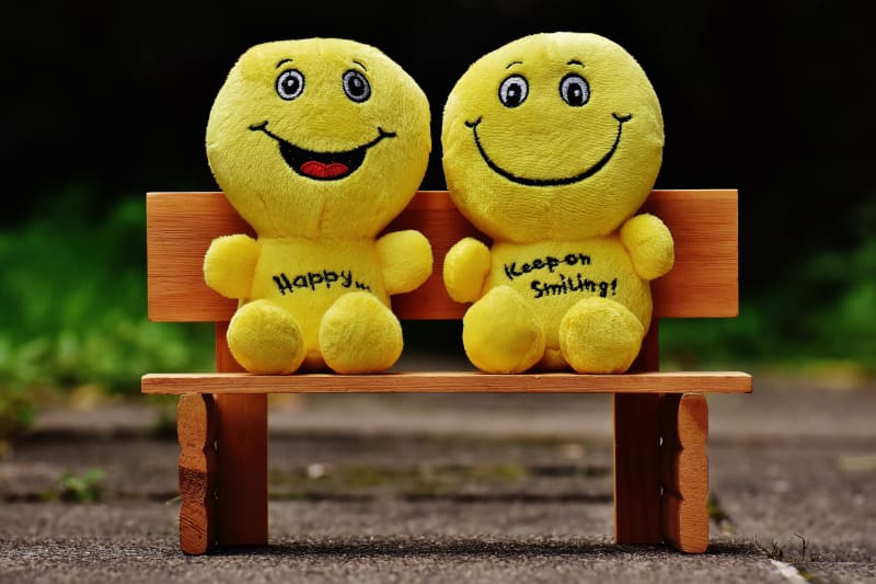 Two yellow plush toys smiling