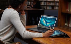 Photo of a woman using her Apple Pencil on an iPad, used as an extended display for a MacBook