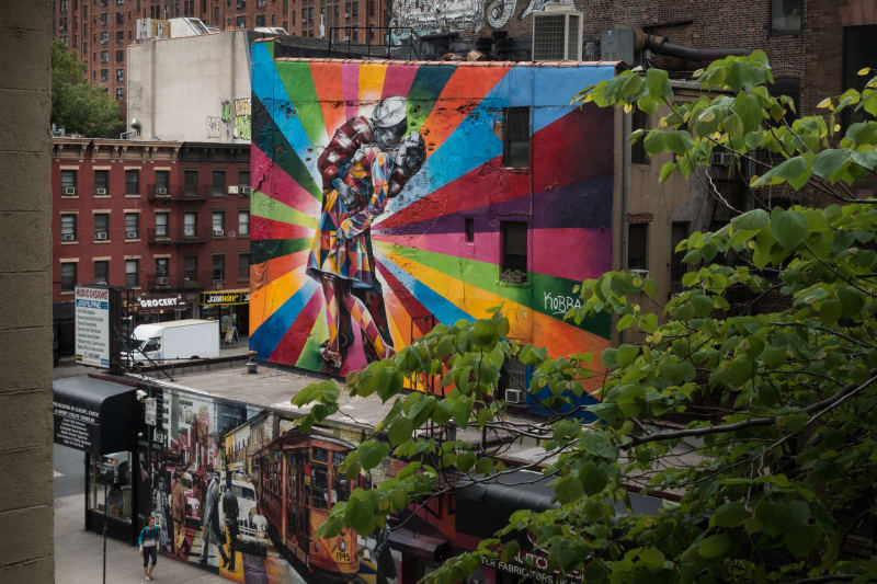 Photo of a very colorful mural depicting the famous photo of an American sailor hugging and kissing a woman