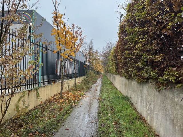 Un sentier étroit entre deux entrepôts dans la zone industrielle de Wissous