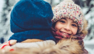Two people hug, staying warm, in the cold