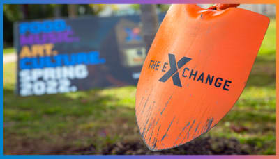 The Exchange logo on an orange shovel, breaking ground.
