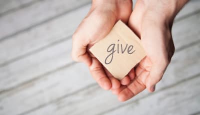 Hands held together, word "give".