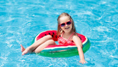 Young girl, smiling, swimming in pool