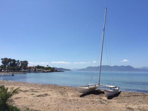 A solitary catamaran sitting on a beach