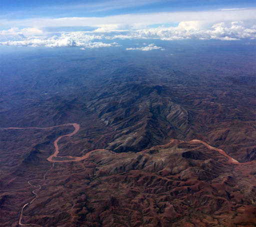 Aerial view of mountains with a ruddy river flowing through