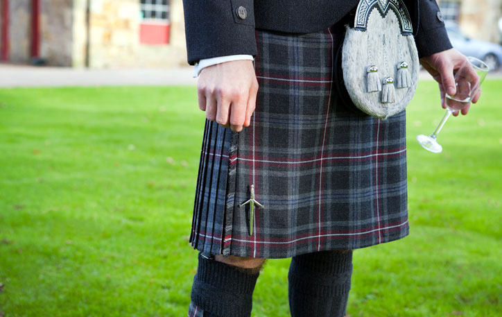 Man in kilt holding champagne glass