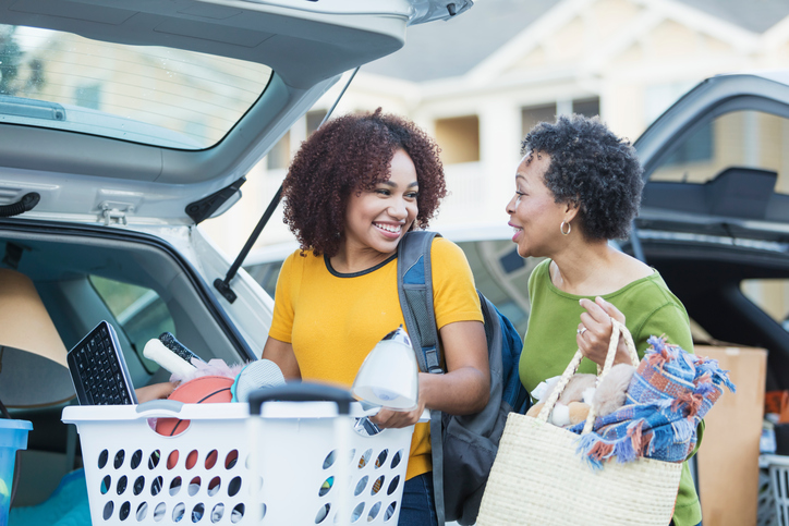 Mother and daughter unpacking car to move into student accommodation