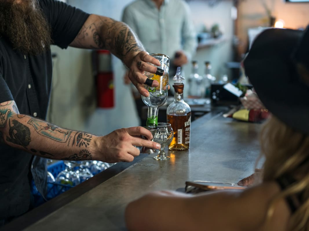Tattooed Bartender Pouring Whiskey Cocktail Bar