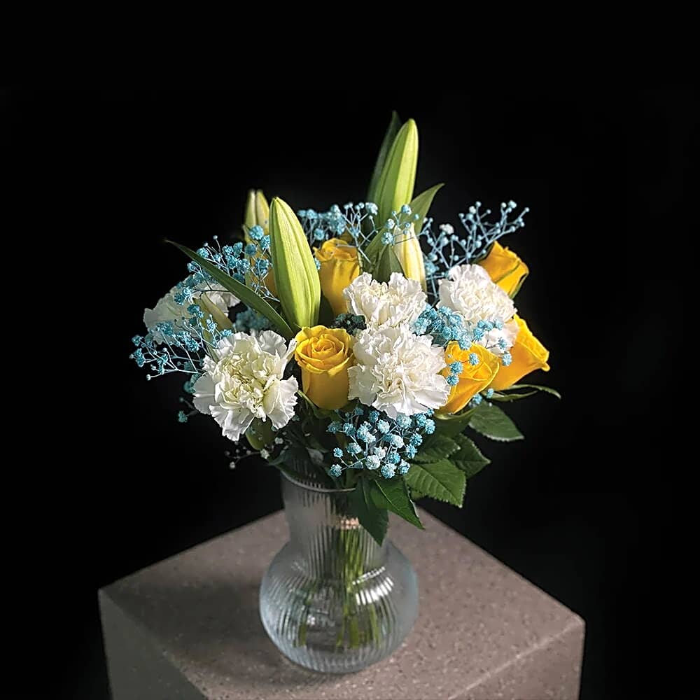 A vase of simple white and blue roses view 1
