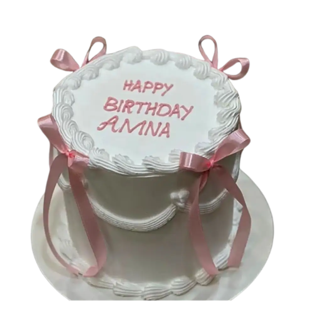 White birthday cake with pink ribbons
