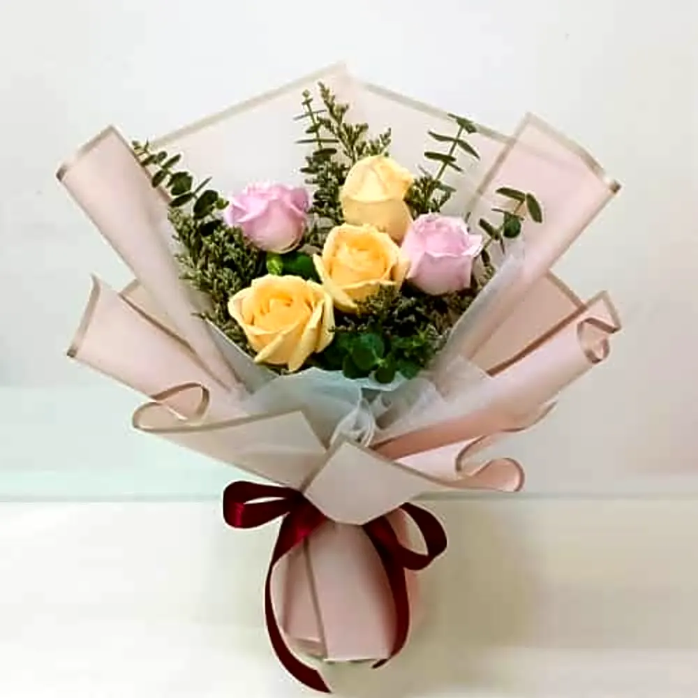 Mixed pink n champagne roses in a hand bouquet