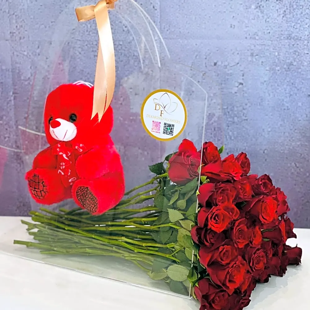 An acrylic bag with red roses and a teddy bear