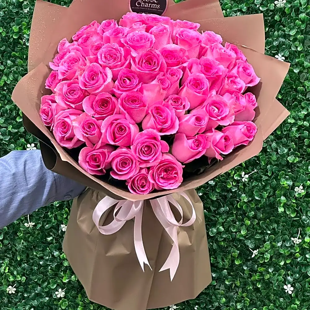 A bouquet of roses with a pink ribbon