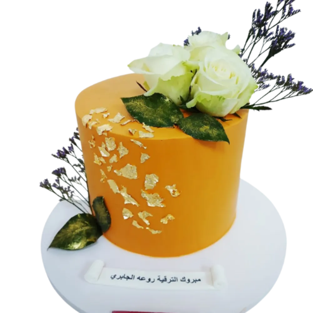 Cake decorated with gold leaf with white roses and leaves