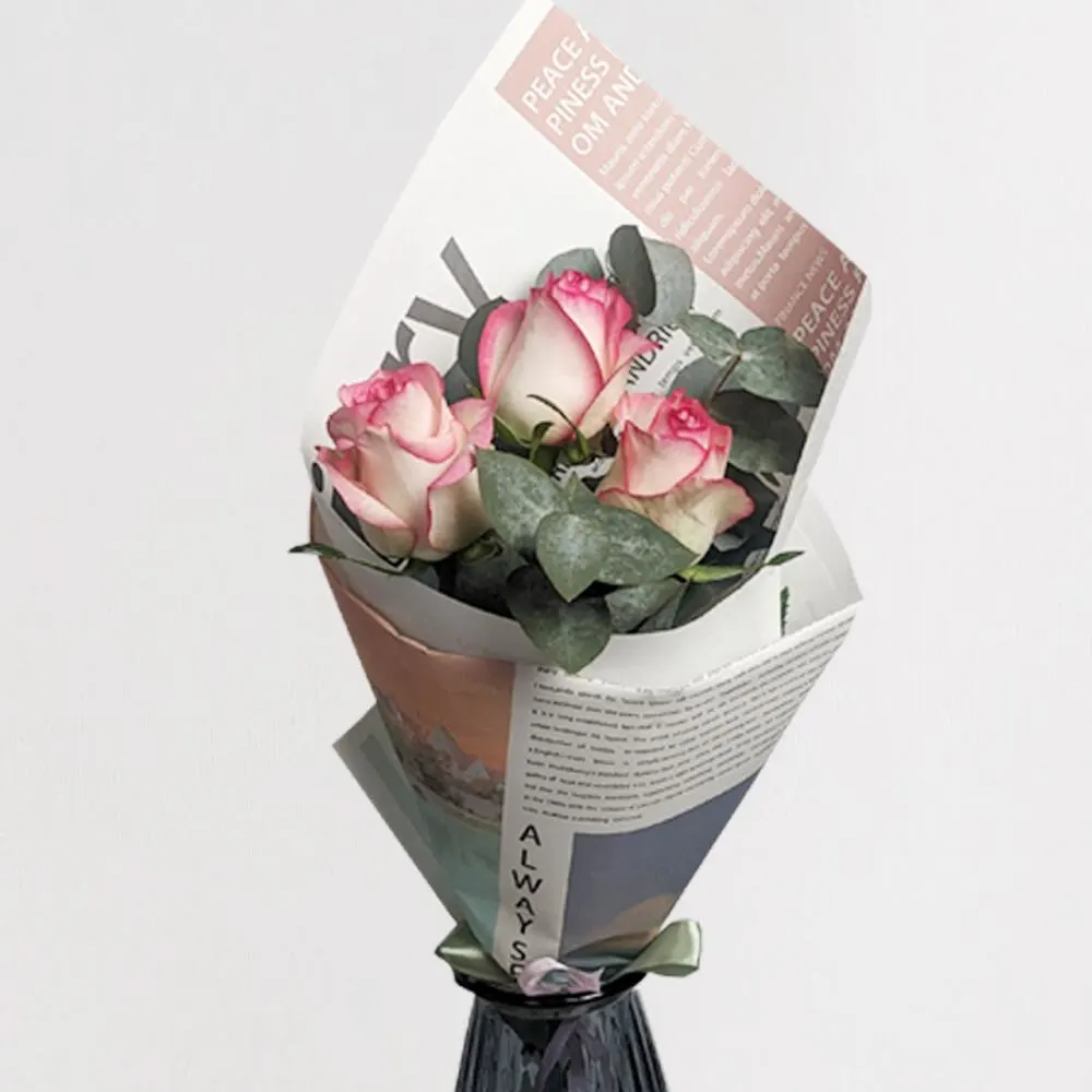 Three Pink roses with eucalyptus in a newspaper package
