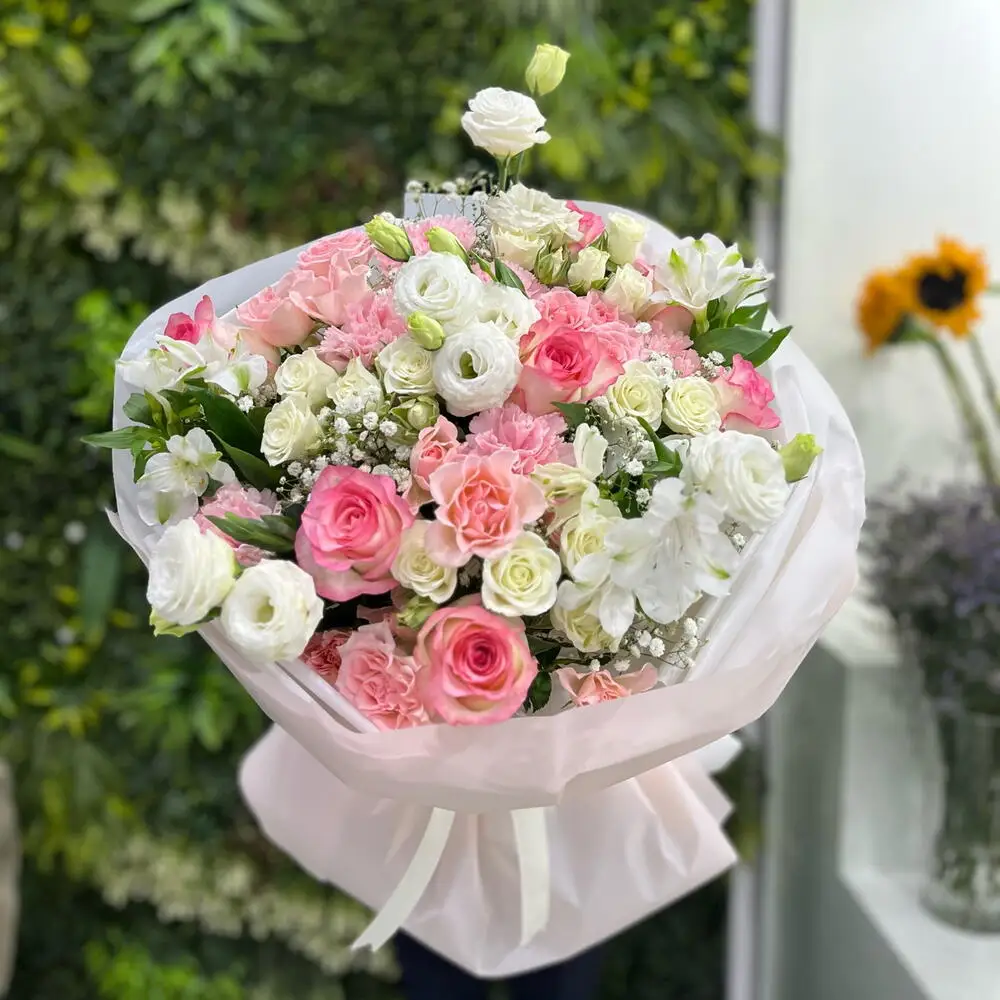 A pink rose bouquet with a purple wrapper
