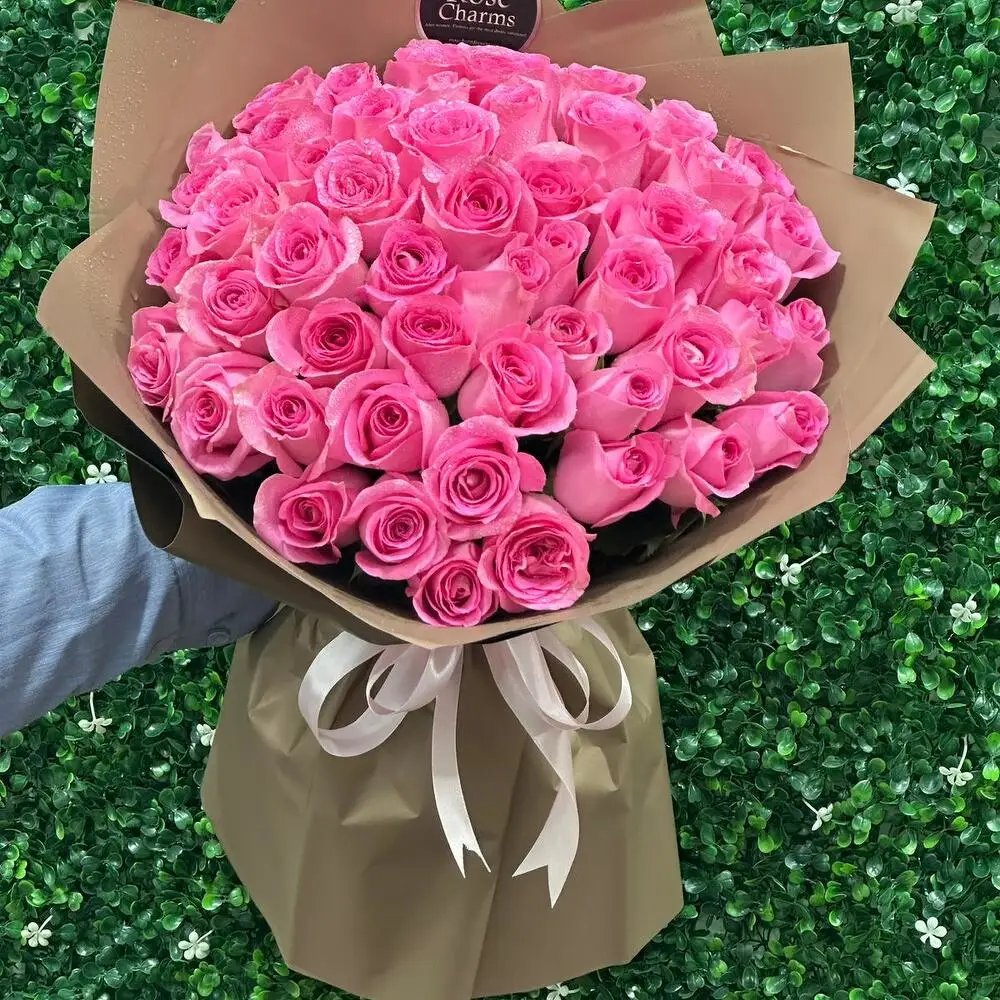 A bouquet of roses with a pink ribbon