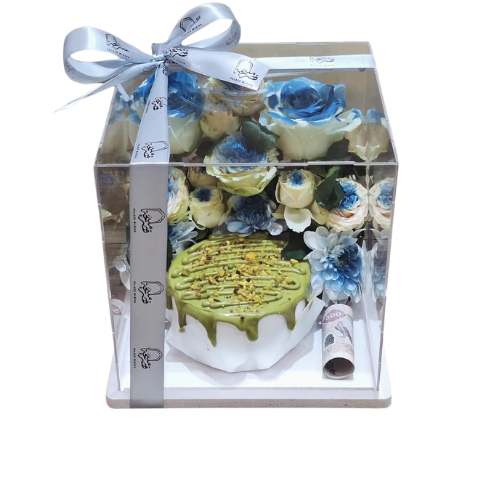 Pistachio cream cake with blue roses in a transparent box view 1