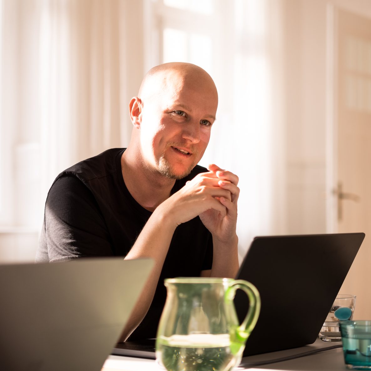 nion Geschäftsführer Sebastian Weyrauch sitzt in einem Besprechungsraum und blickt über den geöffneten Laptop in den Raum