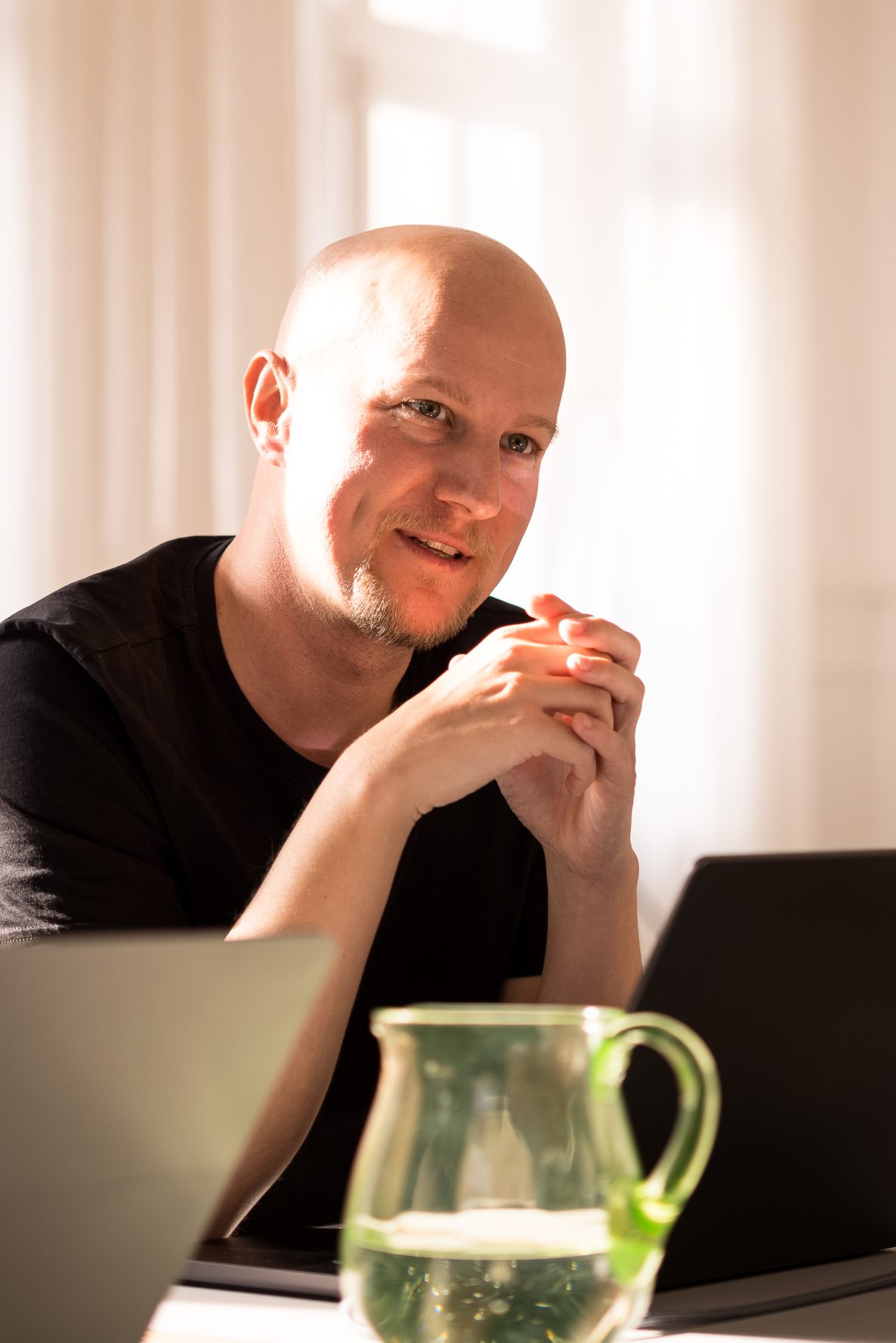 nion Geschäftsführer Sebastian Weyrauch sitzt in einem Besprechungsraum und blickt über den geöffneten Laptop in den Raum