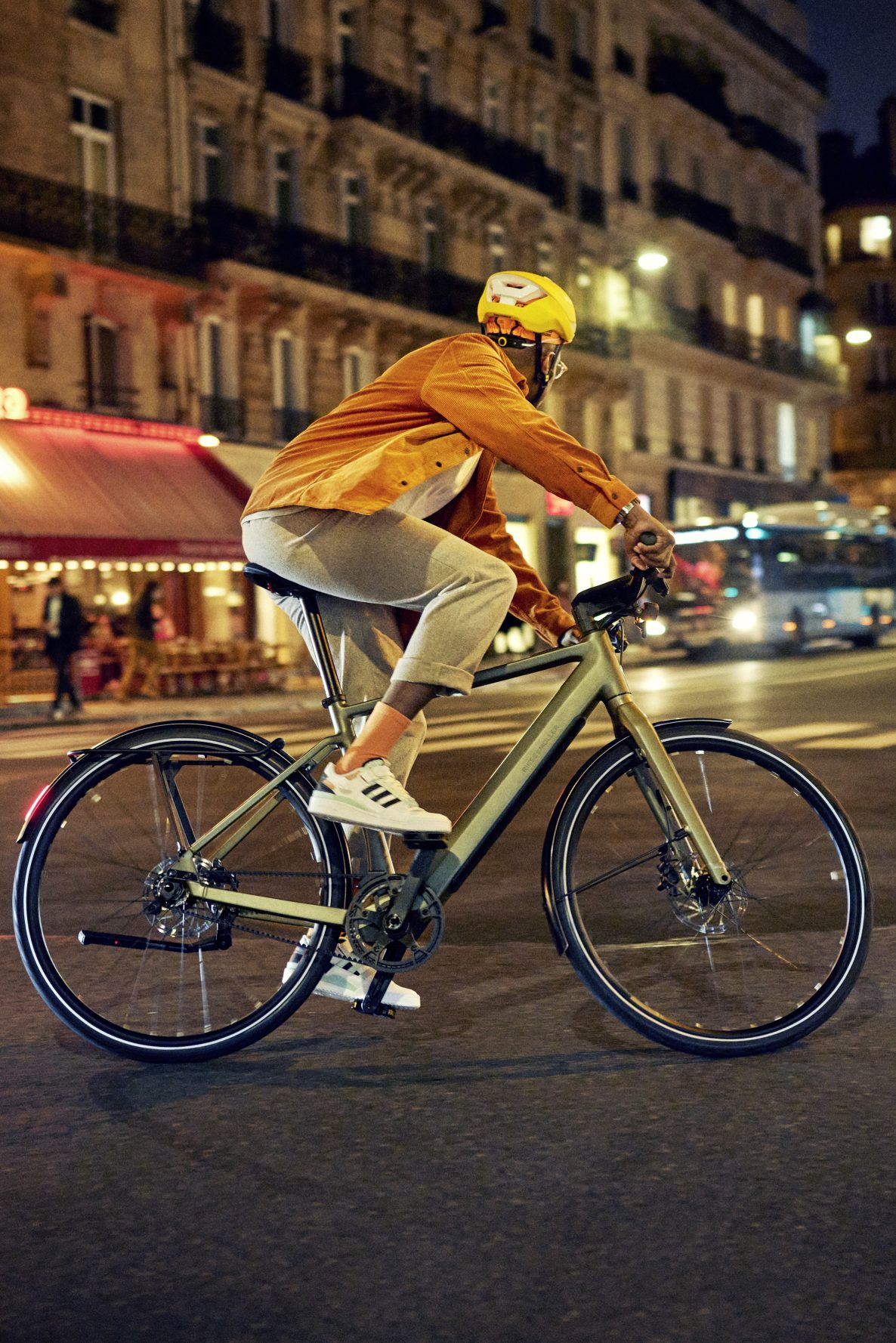 Ein Mann fährt ein Riese & Müller E-Bike in der Stadt bei Nacht.