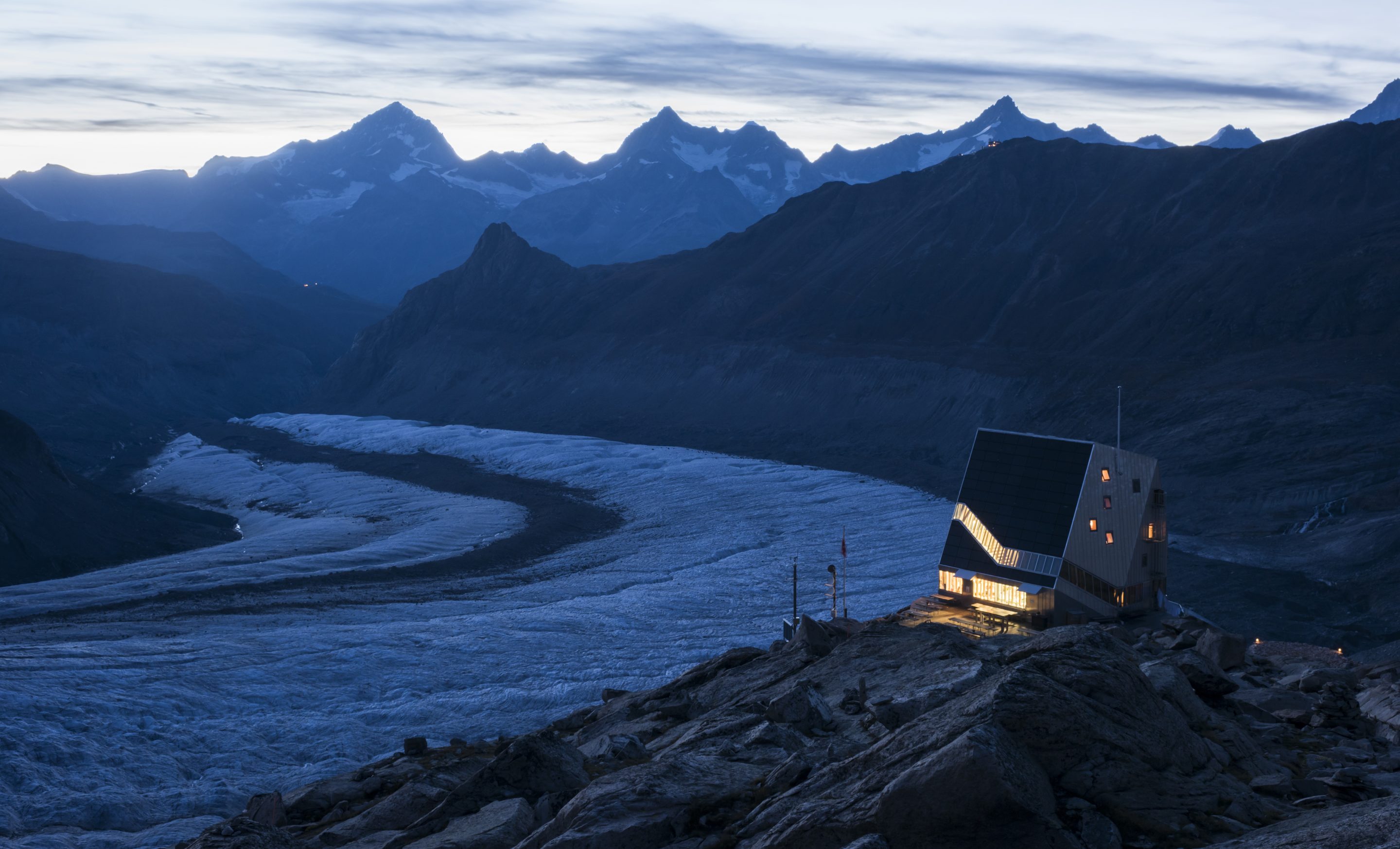Blick auf einer futuristische Schweizer Berghütte vor einem Gletscherfeld und Bergpanorama / Bildquelle: David Schweizer (Goldiwilstrasse 8F, CH-3600 Thun)