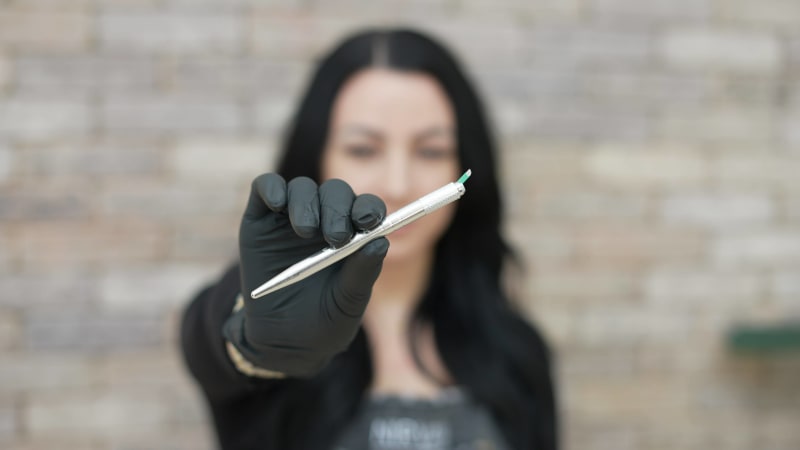 Sarah holding the manual microblading tool she uses instead of a tattoo machine