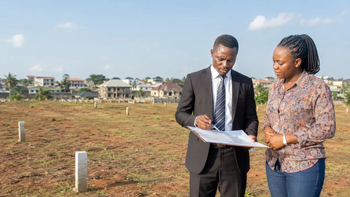 Nigerian property lawyer and buyer reviewing a survey plan on land