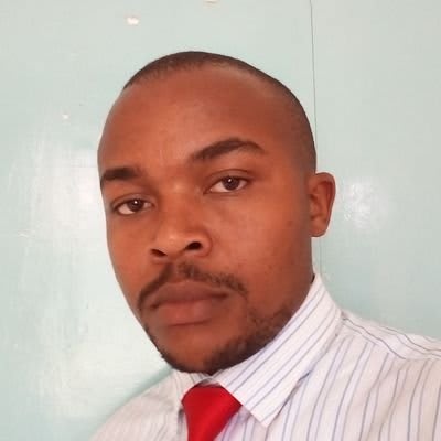 a man with a red tie is posing for a picture in front of a blue wall 