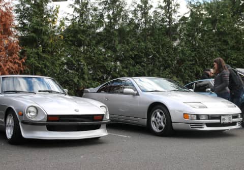 Datsun S30 (280Z wih 240Z carbon fiber bumpers, wide rims & lowered stance) parked next to an identical silver Z32 300ZX that is totally stock.