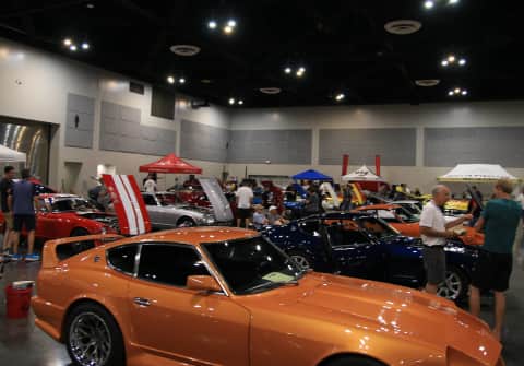 Yellow & black ZAP edition 280Z, a green 280Z and an orange 240Z lined side by side with the hoods open.