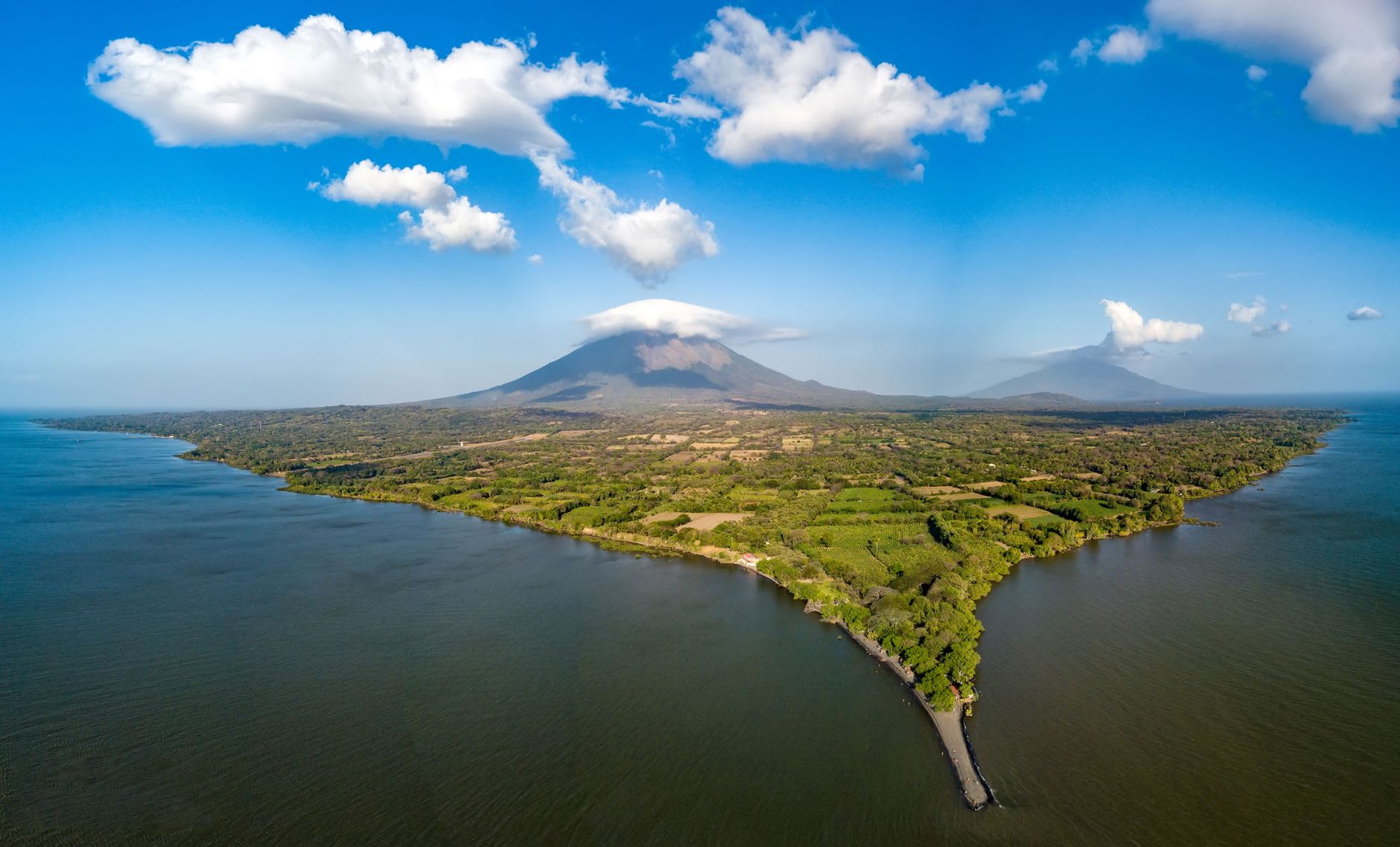 Vue aérienne de l’île d’Ometepe, cône volcanique coiffé de nuages au milieu d’un lac d’eau douce