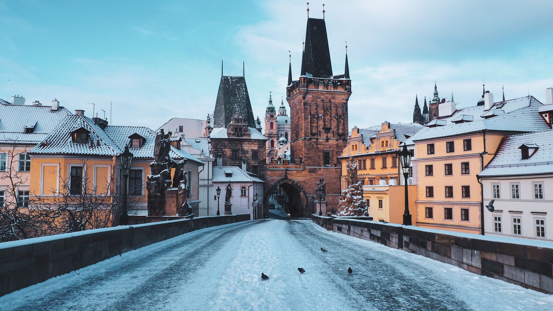Le pont Charles couvert de neige au petit matin, tour de Malá Strana et flèches de la cathédrale Saint-Guy au fond, sans un passant