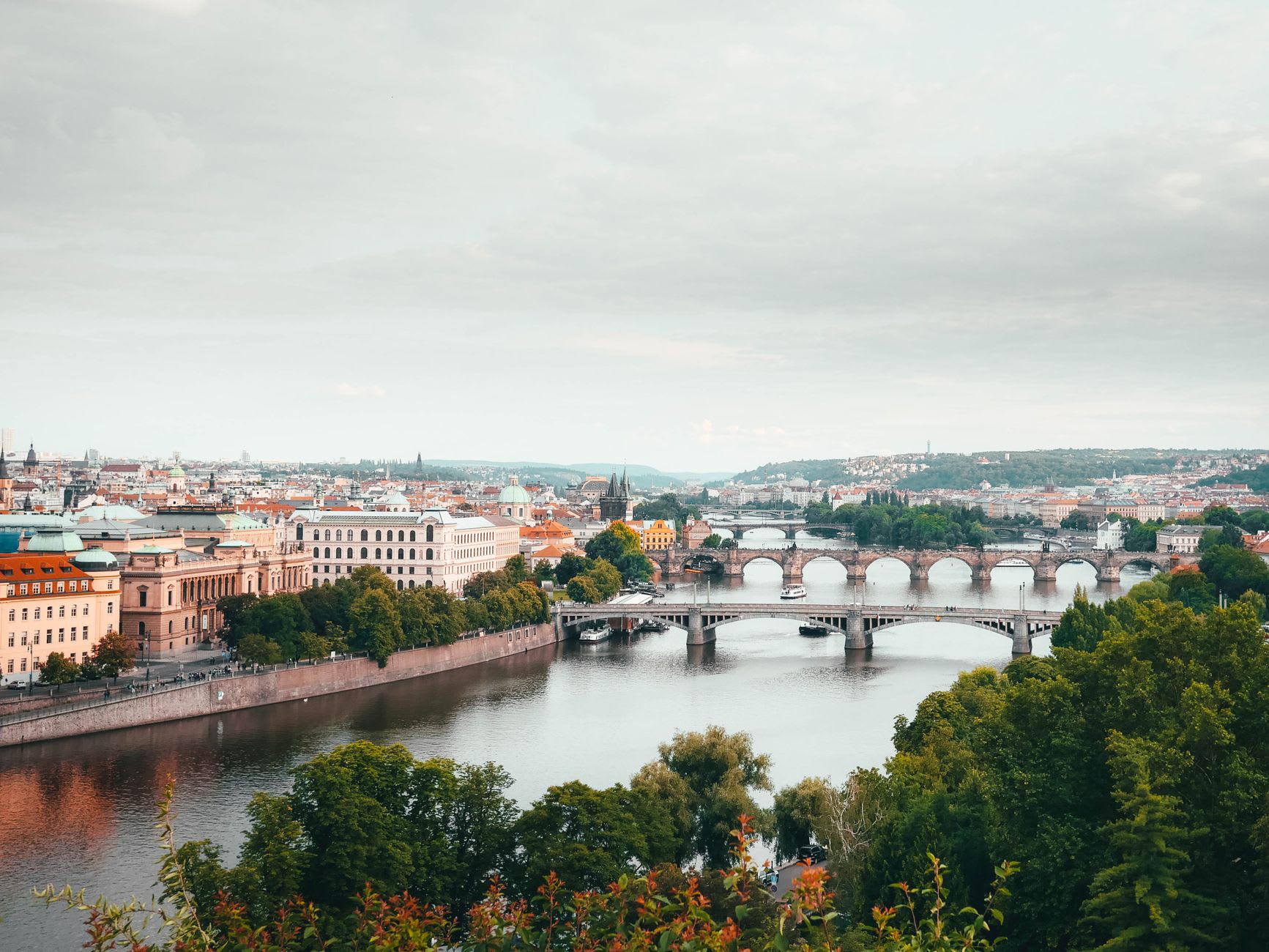 Vue plongeante depuis les hauteurs de Letná sur l’enfilade des ponts qui franchissent la Vltava et sur les toits de la vieille ville