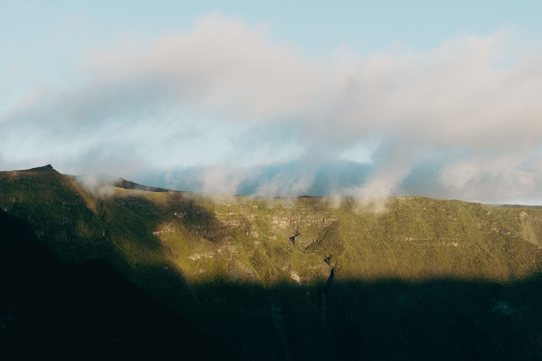 Rempart boisé d’altitude balayé par une écharpe de nuages au soleil du matin, versant vert plongeant dans l’ombre