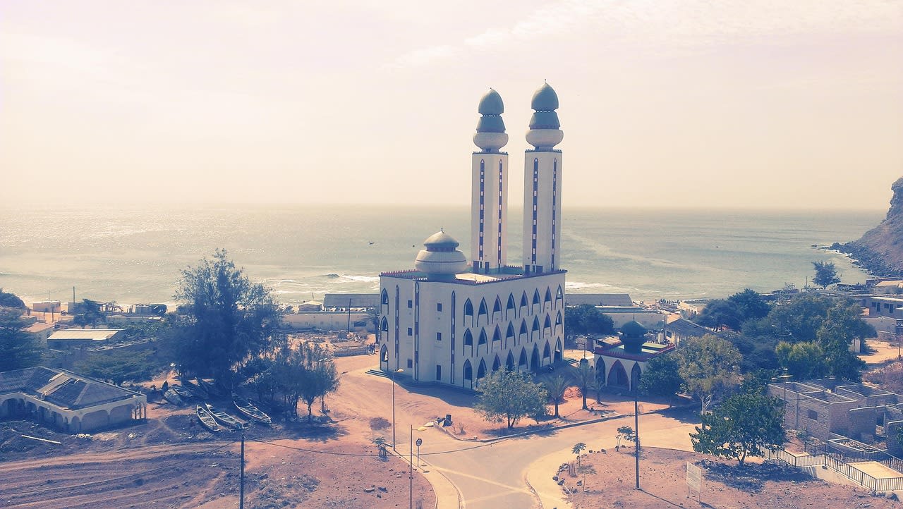 Mosquée à deux minarets posée au bord de l’océan au pied d’une falaise, à Dakar