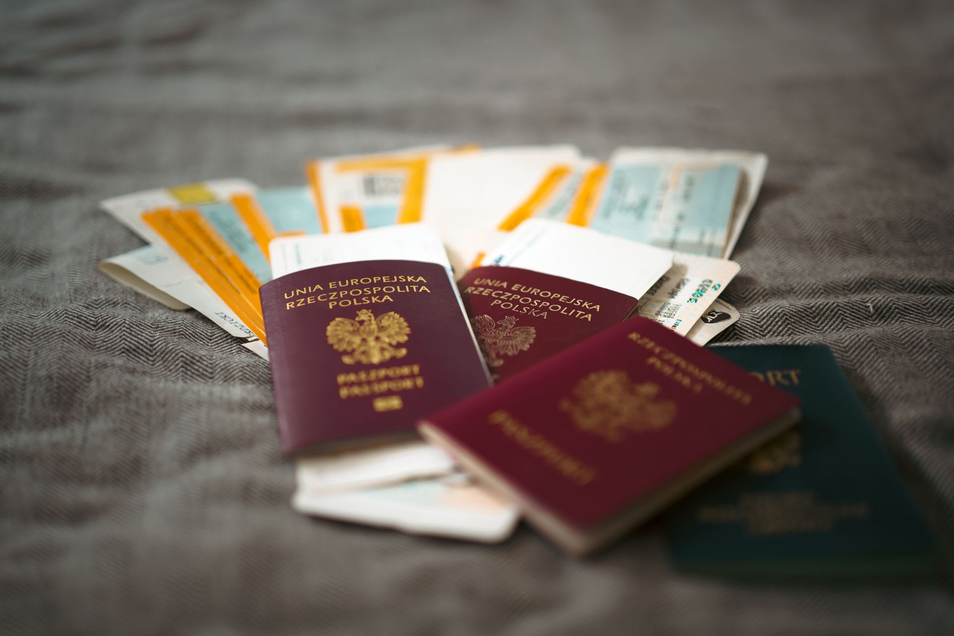 Passeports disposés en éventail avec des cartes d’embarquement et des billets sur un tissu gris