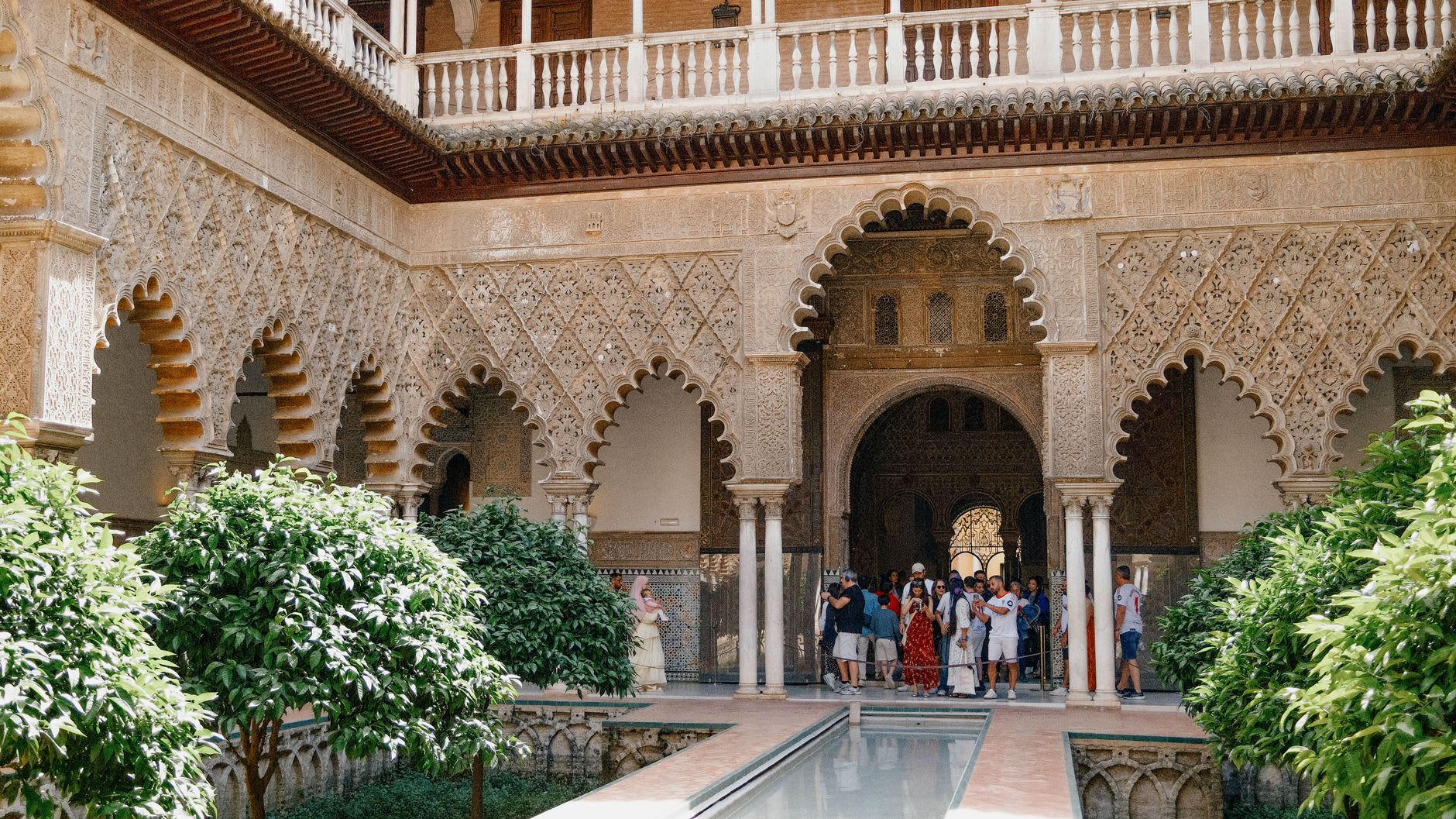 Visiteurs massés sous les arcades du patio des Demoiselles à midi