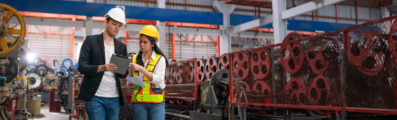 Factory team reviewing production planning and workflow data for manufacturing ERP